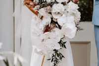 a luxurious modern cascading wedding bouquet with white roses, orchids, greenery and bunny tails is a lovely idea to go for