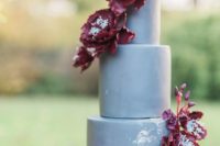 a matte grey wedding cake with burgundy sugar flowers for a luxurious and refined wedding