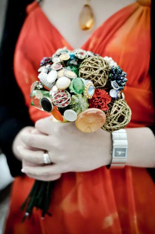 a non typical wedding bouquet of buttons and brooches and glitter yarn balls is a very creative idea