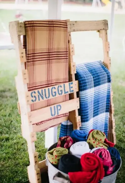 a pallet stand for blankets to keep your guests warm and comfortable during a chilly outdoor ceremony or reception