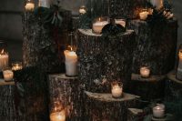 a pretty wedding altar with tree stumps, candles and greenery is a beautiful idea for a rustic or woodland wedding