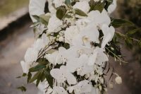 a super elegant white cascading wedding bouquet with roses, orchids and greenery is a timeless idea for a modern bride