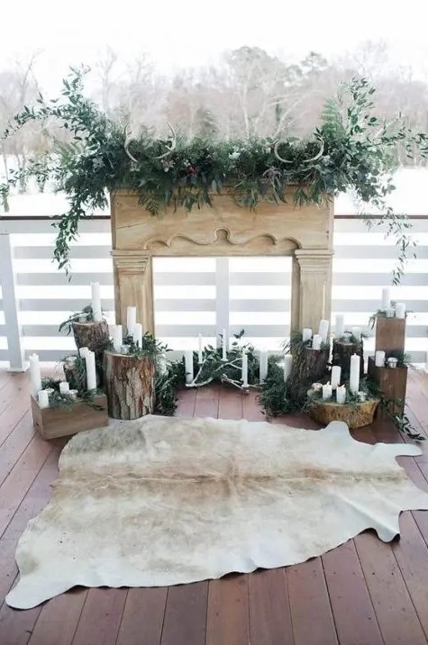 a super natural winter wedding ceremony space with tree stumps, greenery, antlers and foliage and an animal skin rug