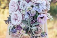 a tender lilac cascading wedding bouquet with lots of various blooms and some pale greenery for a spring bride
