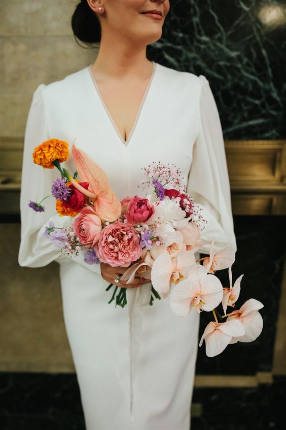 a unique cascading wedding bouquet with pink peony roses, blush orchids, some purple and orange blooms is a cool solution for a modern bride