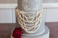 a vintage-inspired grey wedding cake with sugar lace and sugar pearls plus fresh burgundy blooms on top