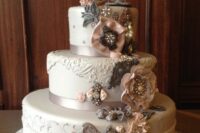 a vitnage wedding cake decorated with ribbon blooms with brooches, a monogram on top, some pearls and some chic vintage decor