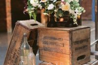 a wedding decoration of crates, bottles, candles and a white floral arrangement is a lovely idea for a laid-back wedding