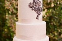a white wedding cake decorated with ribbons and a bit of vintage brooches is a very chic and refined idea