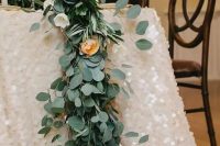 blush chunky sequins and a fresh eucalyptus table runner create a gorgeous glam tablescape