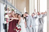 groomsmen wearing dove grey suits and burgundy accessories, bridesmaids wearing burgundy maxi dresses