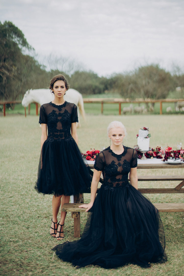 two brides wearing matching chic and sparkling black wedding dresses of different lengths