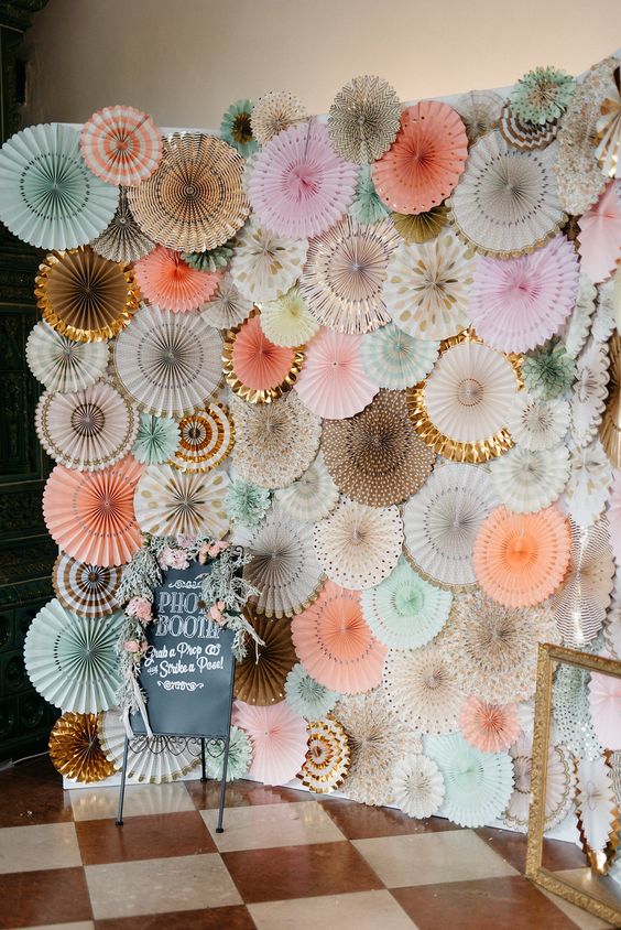 a beautiful pastel paper fan wedding backdrop with a bit of lace and blooms is a stylish idea for the ceremony and taking pics