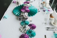 a bold wedding table runner composed of turquoise, grey and purple paper fans is a lovely idea for a modern wedding