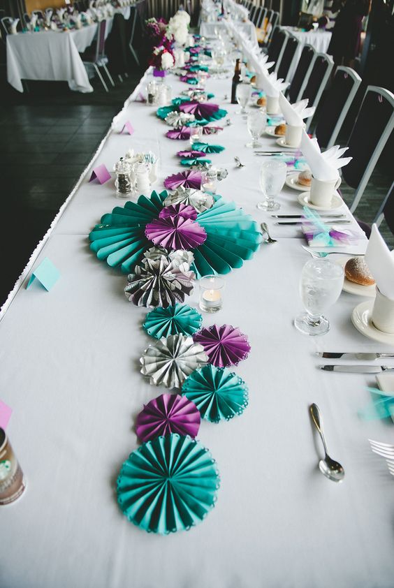 a bold wedding table runner composed of turquoise, grey and purple paper fans is a lovely idea for a modern wedding