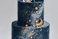 a celestial wedding cake done in navy, with silver touches, little stars and moons in blue, white and copper, with chocolate shards and purple sugar swirls on top