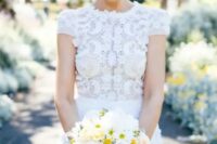 a chic modern wedding dress with a lace applique bodice, a high neckline and short sleeves plus a plain skirt is wow