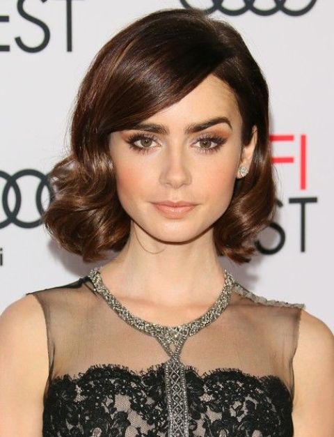 a chic vintage wavy hairstyle with a side fringe and a small volume on top looks very stylish