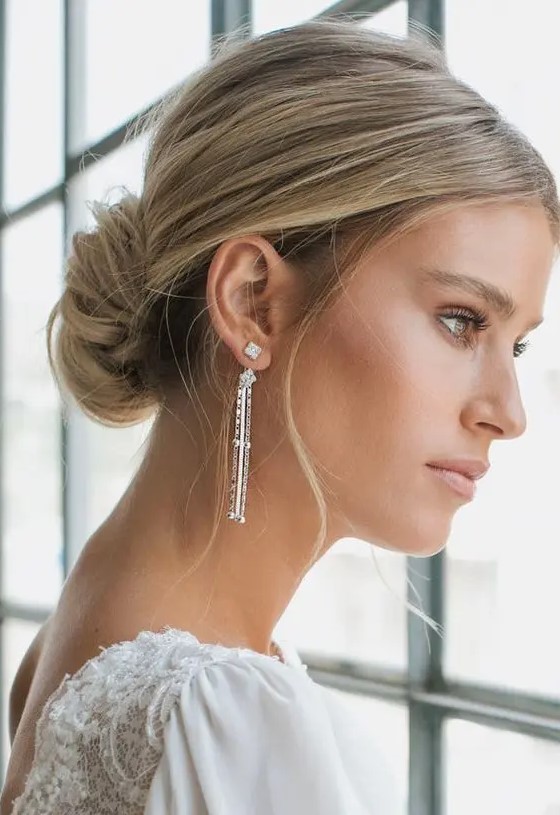 a classic low chignon with a volume on top and some locks down is a beautiful and cool hairstyle for a modern refined bride