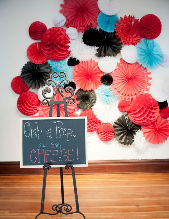 a colorful wedding backdrop composed of blue, red, white and black paper fans and balls looks amazing and super cool