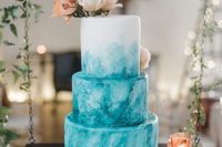 a fabulous turquoise watercolor wedding cake with gold touches, neutral and blush blooms on top and berries is a lovely idea for a summer wedding