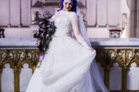 a gorgeous lace princess-style wedding gown with illusion sleeves and a neckline, a tain, purple hair and a dramatic bouquet