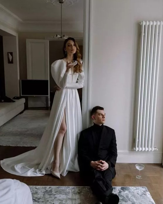 a gorgeous modern yet vintage-inspired plain wedding dress, a plunging neckline, puff sleeves, a thigh high slit, the train is amazing