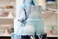 a gorgeous multi-tier wedding cake wiht navy, light blue marble tiers, silver leaf looks like real blue marble and inspires and wows