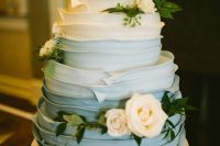 a gorgeous ombre textural powder blue wedding cake decorated with neutral blooms and greenery