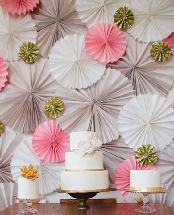 a grey, wihte and pink plus gold glitter paper fan wedding backdrop is a nice idea for a wedidng dessert table