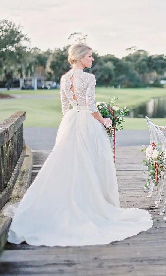a high neckline A-line wedding dress with a lace top, half sleeves and a full skirt, keyholes on the back