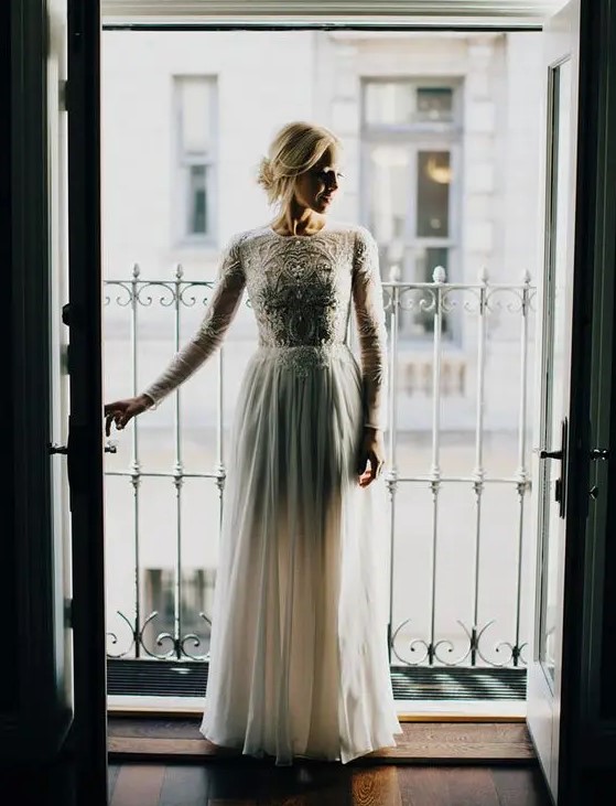 a high neckline long sleeve wedding dress with an embroidered and embellished bodice and a plain skirt