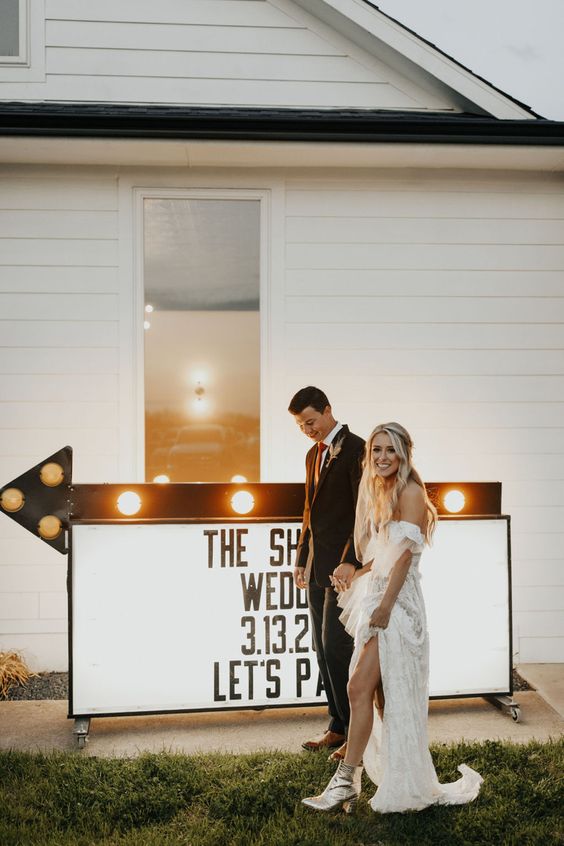 a large sign accented with a marquee arrow is a cool idea for a more relaxed wedding, you can DIY one yourself