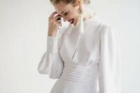 a modern take on a vintage wedding dress – a plain turtleneck Victorian-inspired wedding gown with long sleeves and tassel earrings
