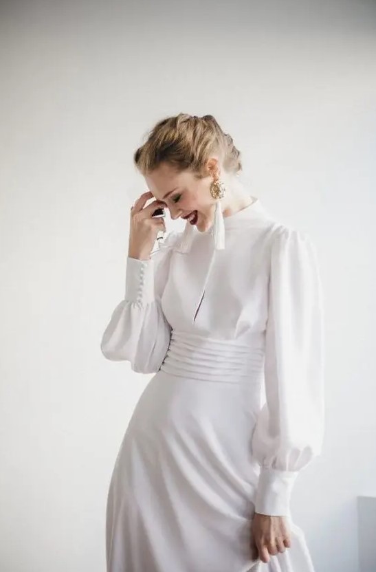 a modern take on a vintage wedding dress - a plain turtleneck Victorian-inspired wedding gown with long sleeves and tassel earrings
