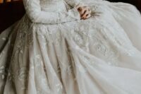 a modest but jaw-dropping A-line wedding dress with long sleeves, lace appliques, a bateau neckline
