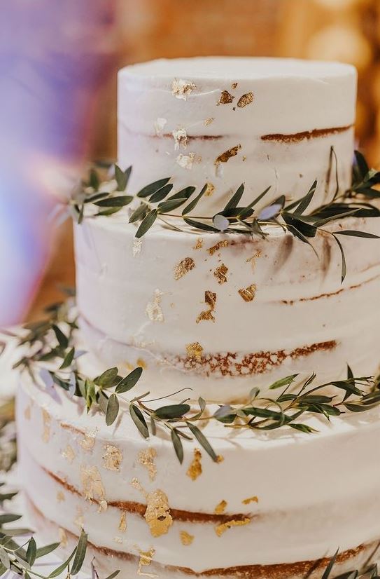 a naked wedding cake with gold leaf and greenery is a timeless idea for many kinds of weddings
