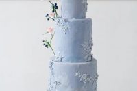a pale blue wedding cake with watercolor tiers, with sugar flowers and twigs, berries and pink blooms is a gorgeous idea for a spring wedding