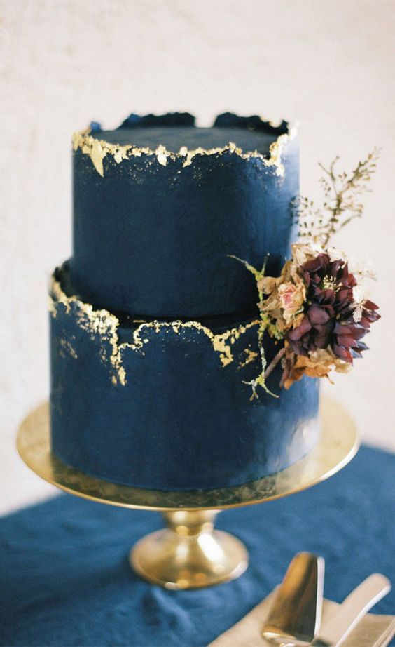 a refined and chic bold navy cake with a rough golm rim, with dark blooms and leaves is a very exquisite idea to go for