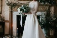 a romantic A-line wedding dress with a lace bodice, illusion sleeves and a neckline plus a high low skirt with a train