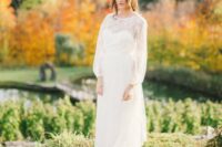a romantic wedding dress with a lace overdress with long sleeves and a train with a vintage feel