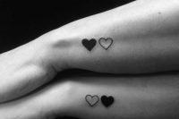 a sheer and a black heart tattoo on the side of thw wrist is a cool and bold idea for every modern couple