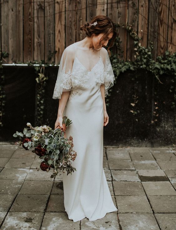 a slip plain wedding dress paired with a sheer capelet and a lace trim are a gorgeous combo for a wedding in a church