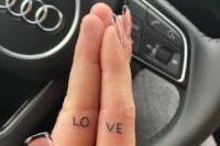 a small LOVE tattoo split into two parts and palced on your fingers is a very modern and fresh idea