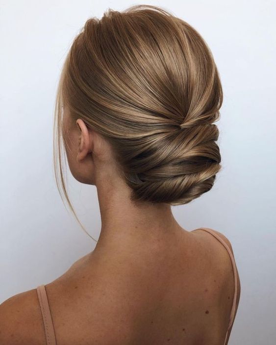 a sophisticated modern twisted updo with a sleek yet deimsnional top and a bit of locks to frame the face is a great idea for a formal wedding
