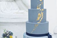 a spring wedding cake with a blue marble and textural blue tiers, with gold leaf and a navy ribbon is a beautiful and timeless idea