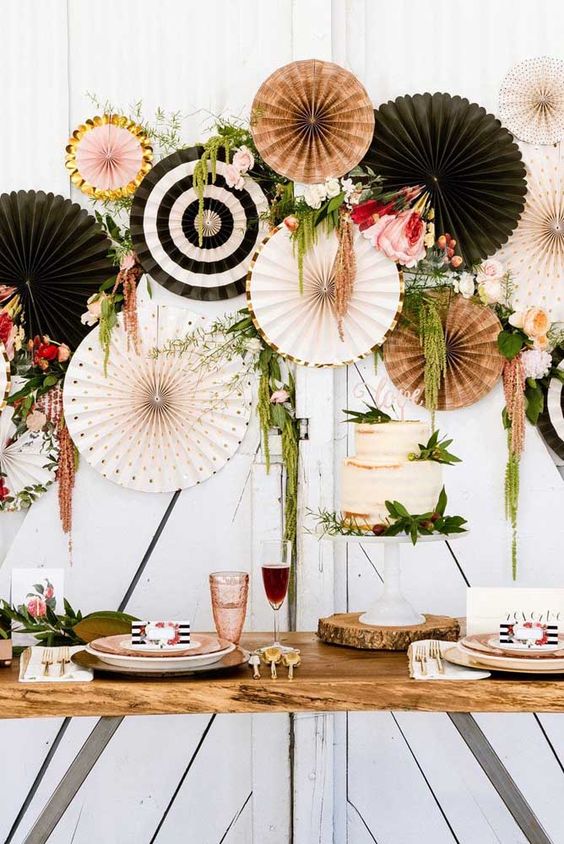 a stylish modern wedding backdrop with blush and black paper fans, with gold touches, pink blooms and berries and greenery is chc