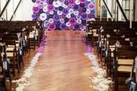 a super bold purple, fuchsia and white paper fan wedding backdrop, matching purple petals on the floor is cool