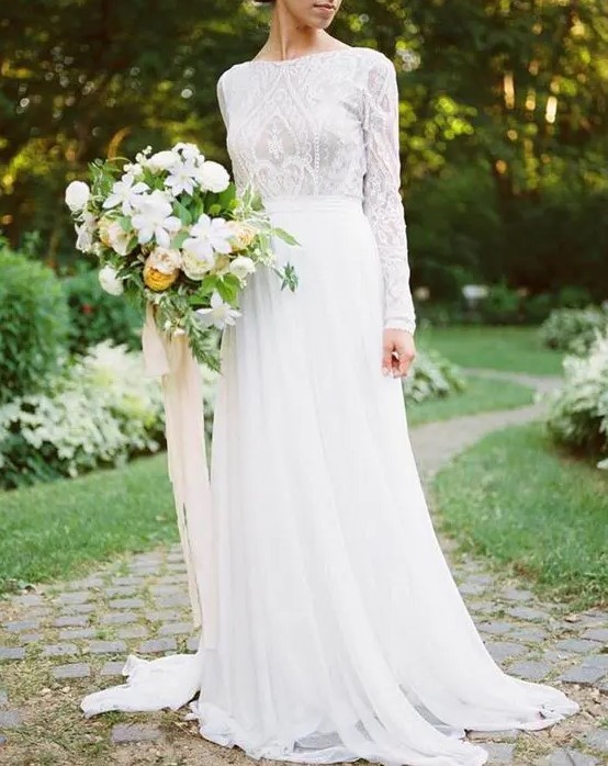 a textural lace bodice with long sleeves and a high neckline and a flowy skirt compose a lovely and chic wedding dress suitable for a church ceremony