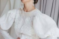 a vintage-inspired A-line wedding dress with a boho lace bodice and a crochet collar, puff sleeves, pearl buttons and statement pear earrings